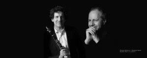 Nicolas BaldeyrouNicolas Stavy Two male musicians in black and white one holding a clarinet posed against a dark background